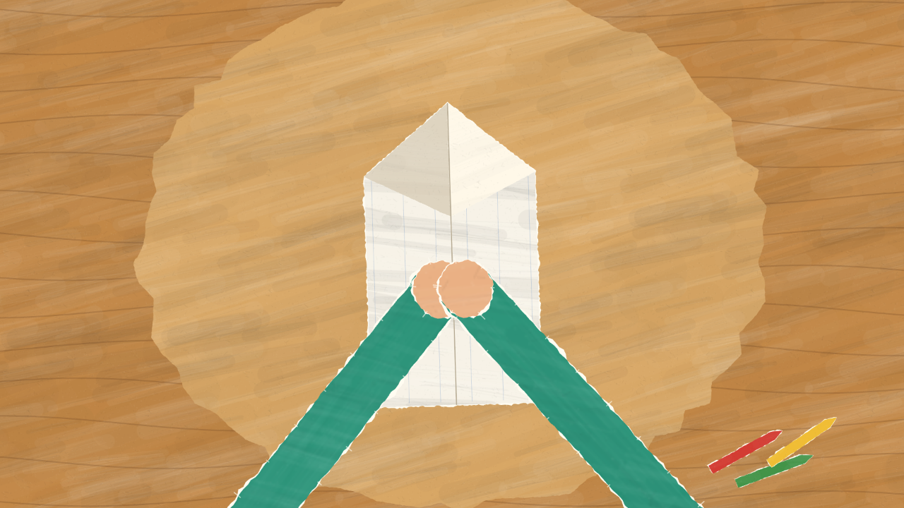 Paper-cutout hands fold the lined sheet into a plane on a wood-textured table, with coloured pencils nearby.